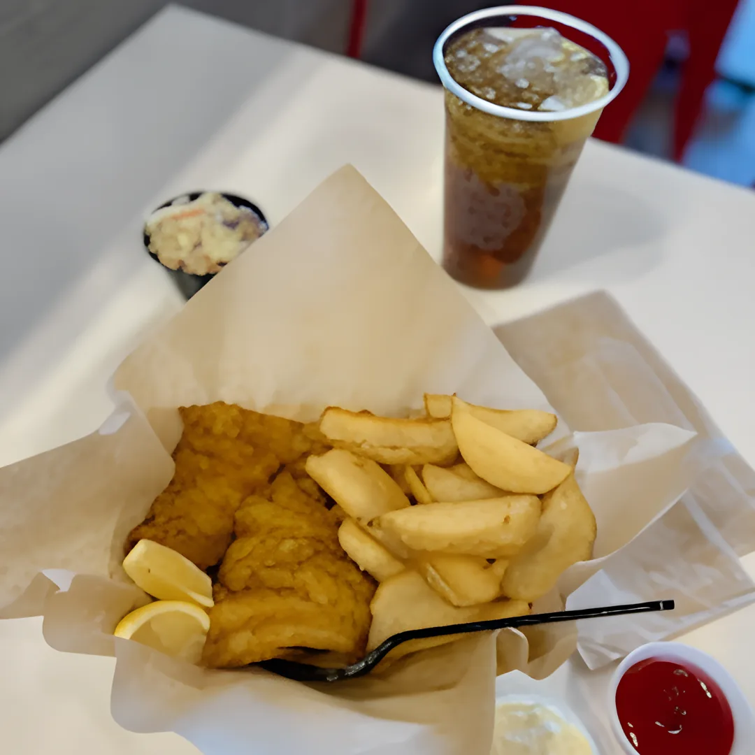 Traditional english dish fish and chips basket with drink